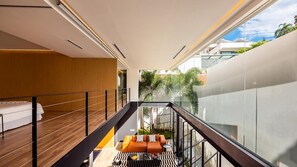 Un interior moderno con balcón, un sofá y vistas a zonas verdes.