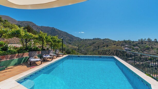 A swimming pool with lounge chairs and a view of a mountainous landscape. - Casa Jazmín Azul Cómpeta by Ruralidays (Málaga)