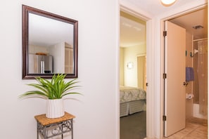 Relax in a serene space with a comfortable bed, a stylish table, and a bathroom featuring a shower and toilet.