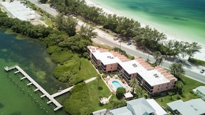Enjoy a serene beachfront setting with a swimming pool, lush greenery, and access to the ocean.