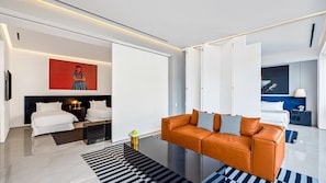 A modern hotel room with a bed, a sofa, a coffee table, and a painting on the wall. - PIER 57 - 208 | 2BR Condo with Best Rooftop View (Puerto Vallarta)
