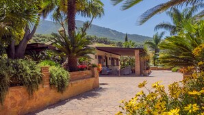 A paved walkway leading to a covered outdoor seating area with a mountain backdrop. - Cubo's Finca Los Dragos. Pool, wifi and AC/heating (Alhaurín el Grande)