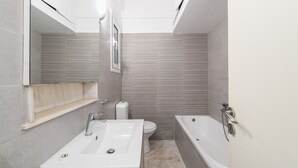 Un baño moderno con lavamanos, inodoro y bañera.