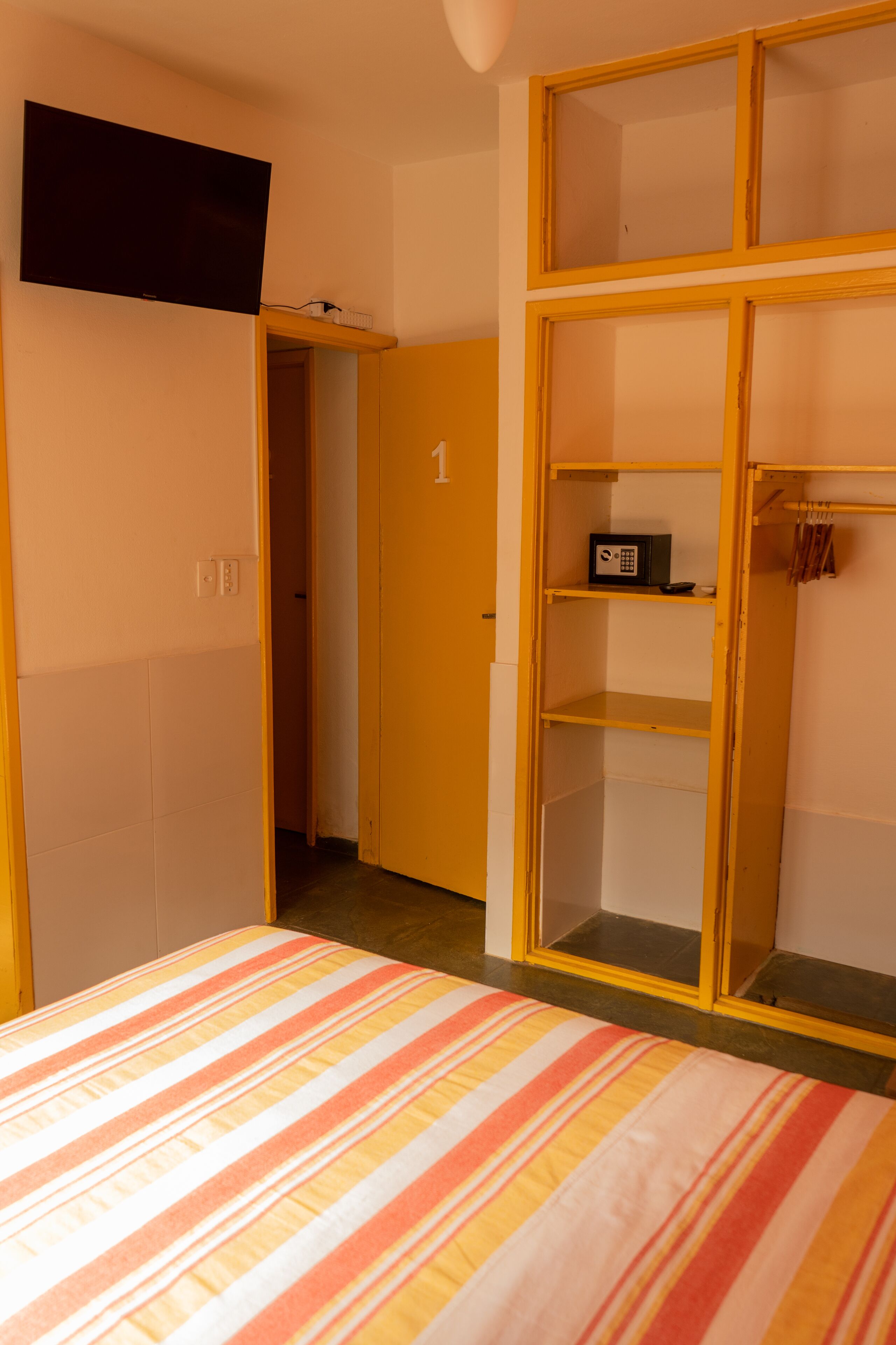 A room with a bed, a wardrobe, and a television.