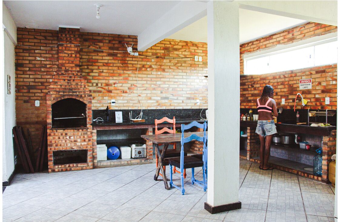 Una cocina con pared de ladrillo, horno de ladrillo y encimera con diversos objetos.