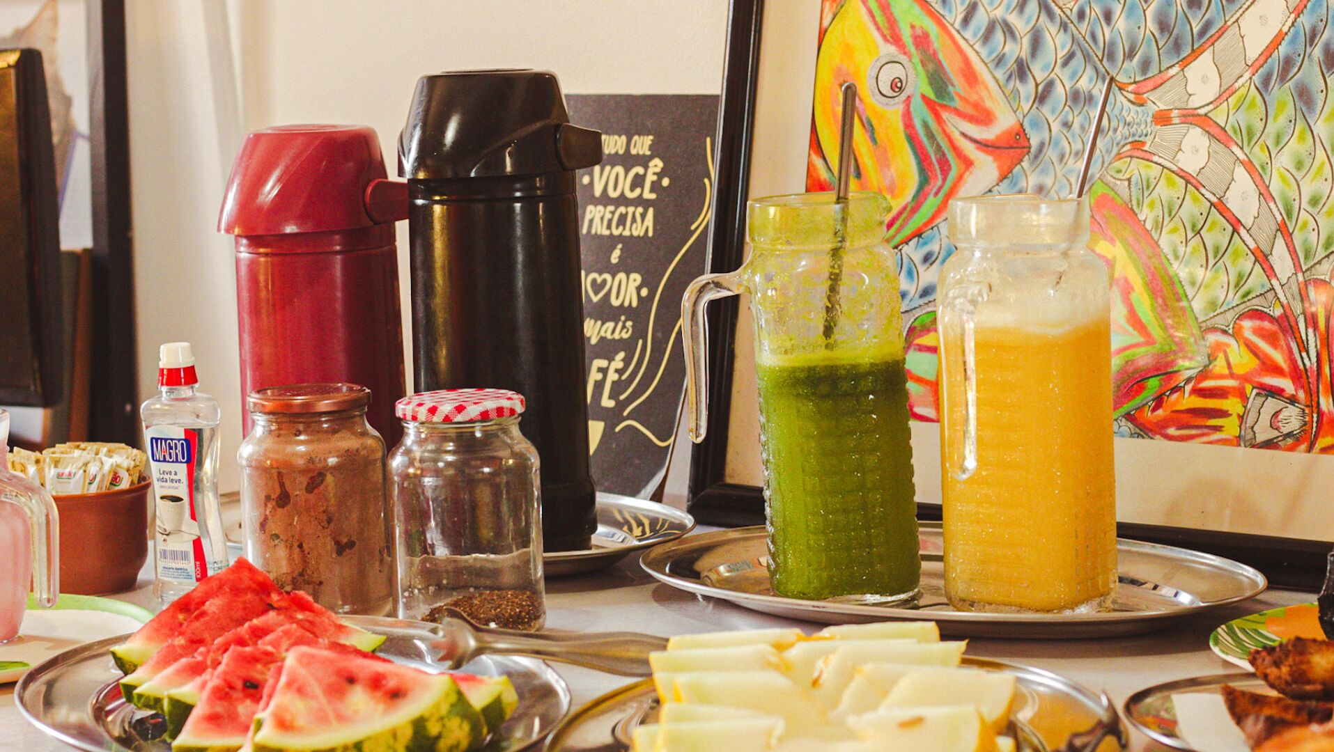 A table with various food items, drinks, and condiments.