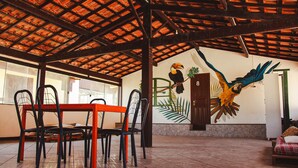 A dining area with a table and chairs, a mural of a toucan, and a door marked with the number 8. - Beach Hostel & Suites, Cabo Frio (Cabo Frio)