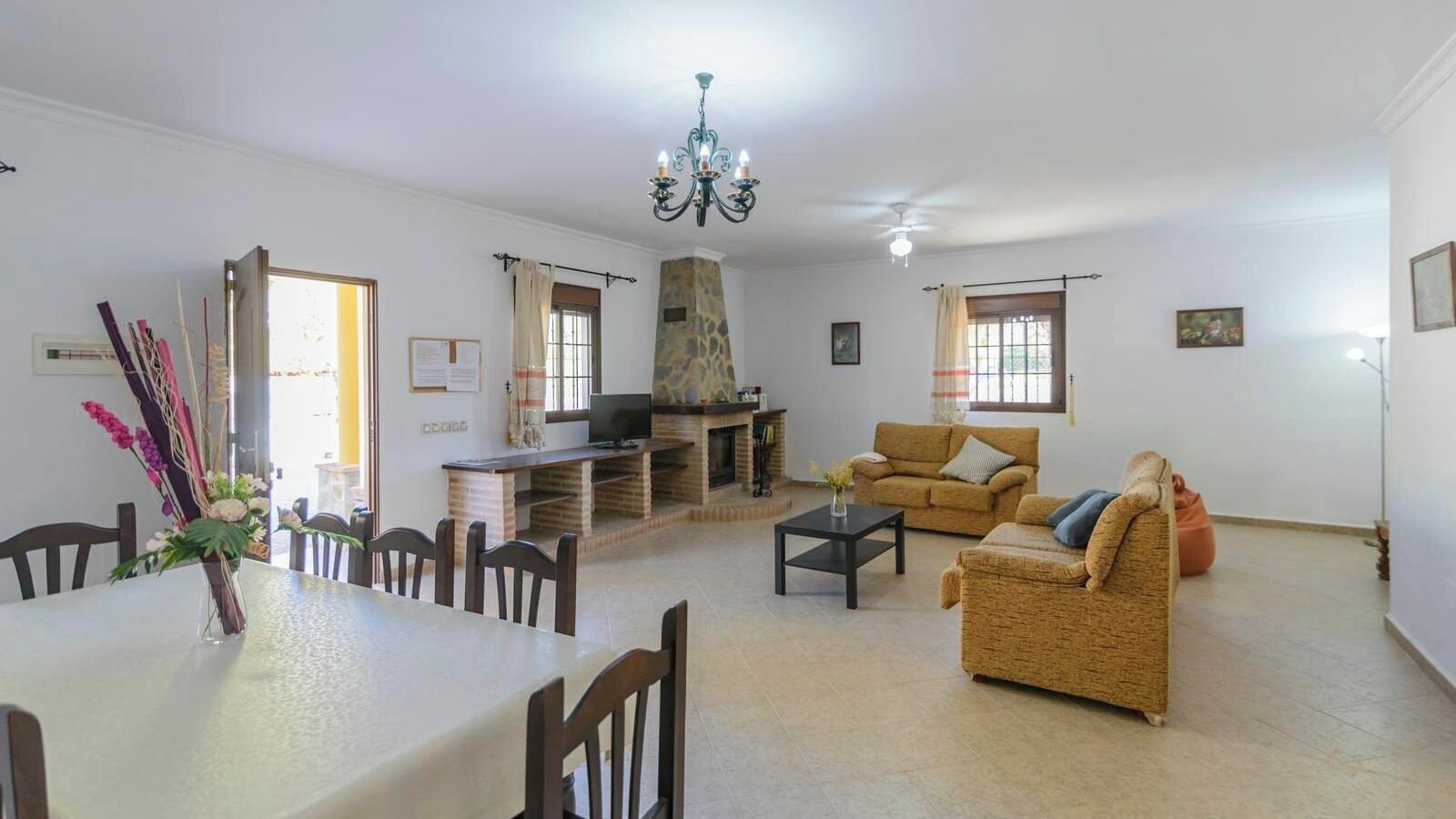 Uma sala de estar com lareira, sofá, mesa de jantar e cadeiras.