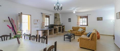 Una sala de estar con chimenea, sofá, mesa de comedor y sillas.