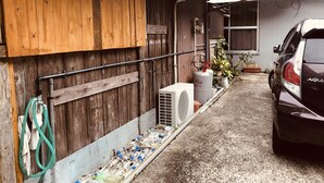 Garagem com carro, aquecedor e mangueira.