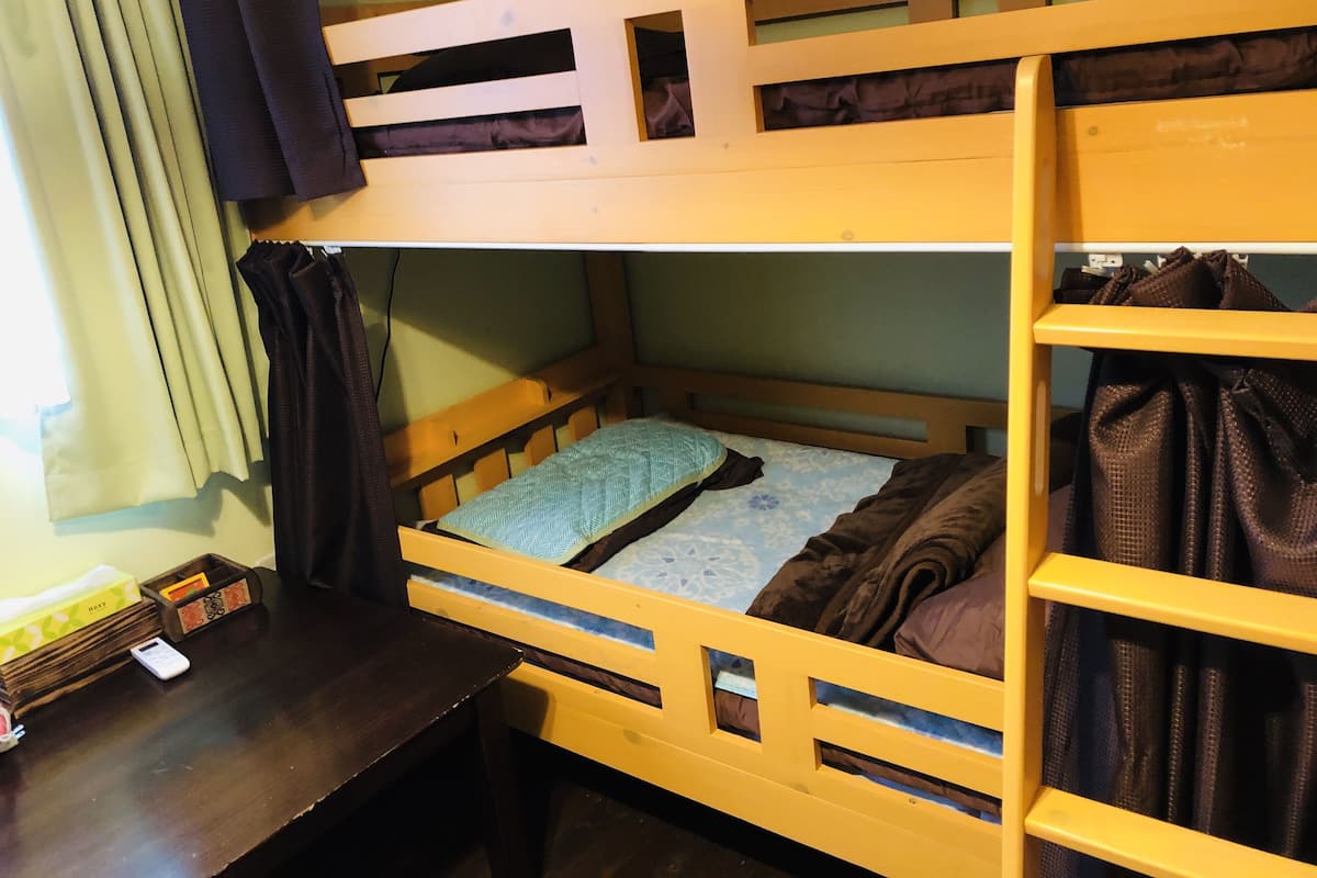 A bunk bed with a desk and a shelf.