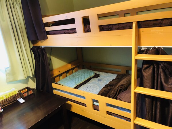 A bunk bed with a desk and a shelf.