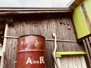 Un edificio de madera rústico con un barril rojo grande etiquetado 