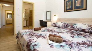 Una habitación de hotel con cama, escritorio, ducha y baño.