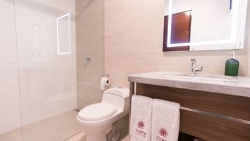 Une salle de bain moderne avec des toilettes, un lavabo et un miroir.