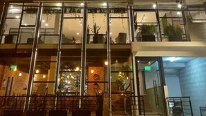 A multi-story hotel with illuminated windows and a glass facade. - Surya Lima (Lima)