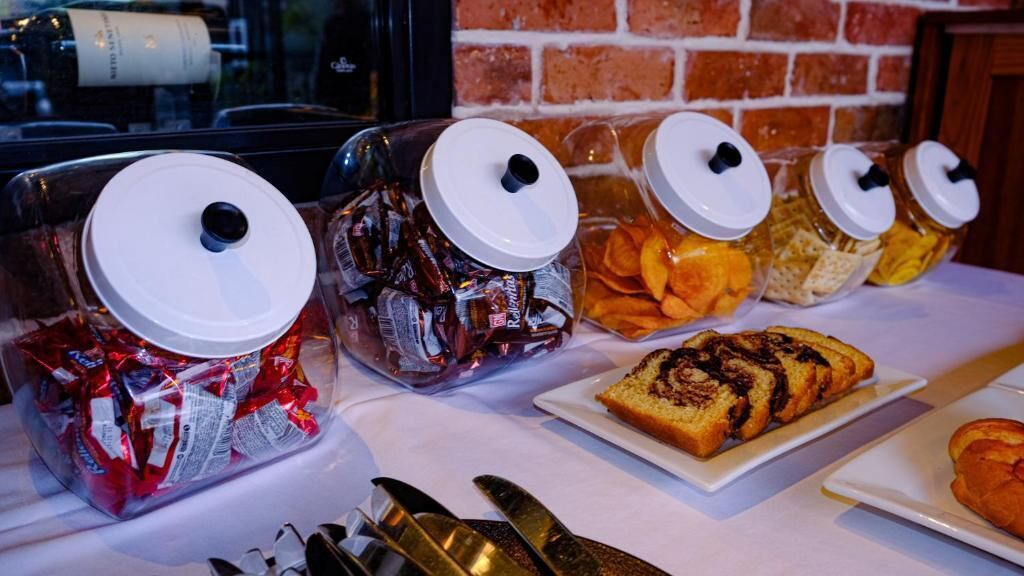 Ein Buffet mit Gläsern voller Snacks und einem Stück Kuchen.