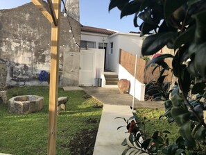 Stroll through the serene garden, where a pathway leads to a cozy outdoor space with a pergola, planter, and rustic accents.