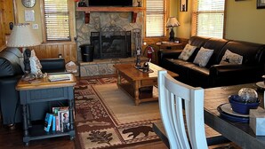 Una sala de estar acogedora con chimenea, televisor, sofá y una mesa de centro.
