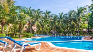 A swimming pool with lounge chairs and palm trees. - Amazing & Great Price -  Free access  to the Beach (Cancún)