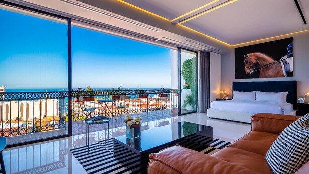 Ein modernes Wohnzimmer mit einem großen Glasfenster, einem weißen Sofa und einem Gemälde eines Pferdes.