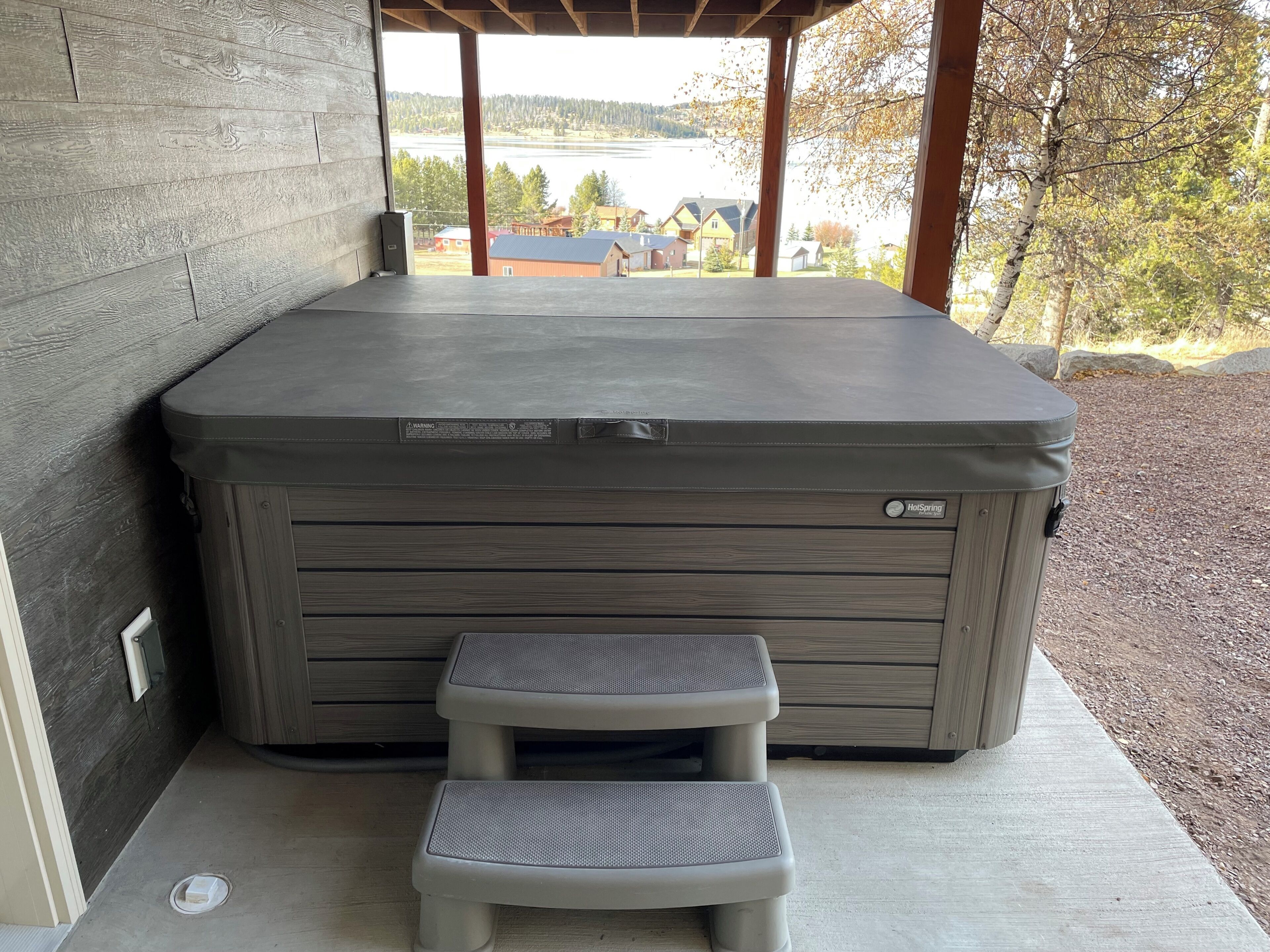 Ein Whirlpool mit Holzverkleidung und einer Sitzbank davor.
