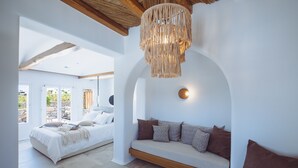 A modern bedroom with a bed, a built-in bench, and a hanging light fixture.