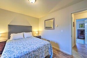 A bedroom with a bed, bedside lamps, a mirror, and a dresser. - Anacortes Condo - Walk to Town, Marina, + Bay! (Anacortes)