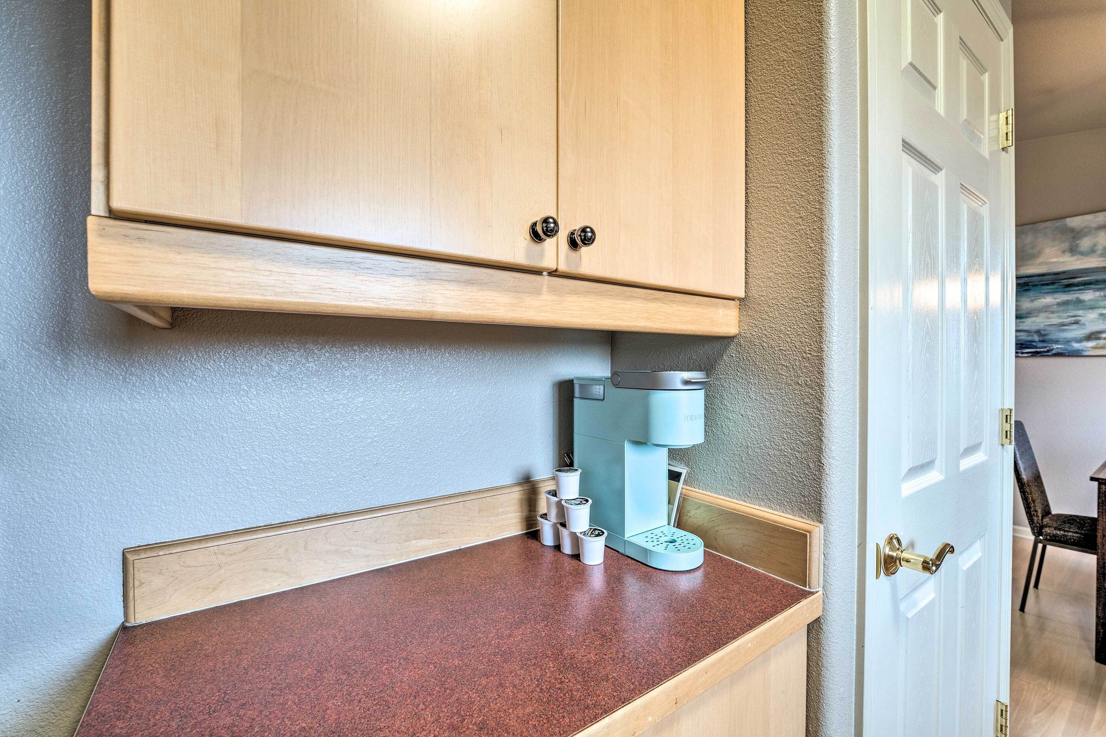 A kitchen with wooden cabinets, a coffee machine, and a countertop.