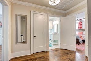 A hallway with wooden flooring, white doors, and a mirror on the left wall. - Howes Capitol–3 in 1-near OU Med, Bricktown, Arena (Oklahoma City)
