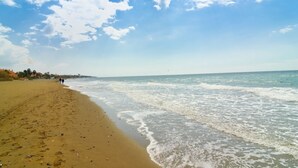 A beach with a sandy shore and waves gently lapping at the edge. - Beachfront Luxury | Renovated 2-Bed Oasis with Pool Access at Alicate Playa (Marbella)