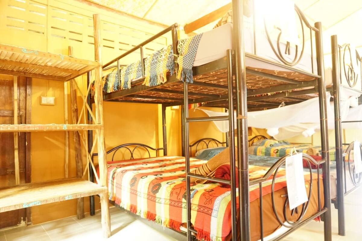 A bunk bed with a metal frame, a shelf unit, and a bench.