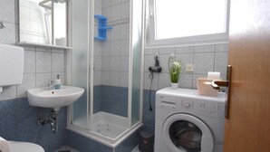 A compact bathroom with a sink, toilet, shower, and a washing machine. - Apartment Sunny on the first floor (Njivice)