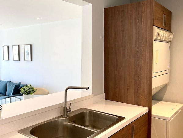 Een moderne keuken met een roestvrijstalen spoelbak, houten kastjes en een ingebouwde oven.