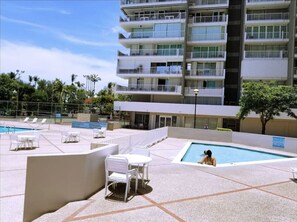 Un espace piscine aménagé sur le toit, avec des chaises longues et une piscine.