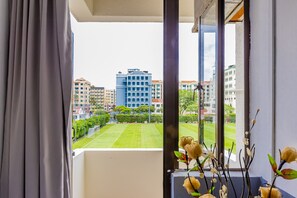 A balcony with a view of a tennis court and buildings. - K Hotel 8 (Singapore)