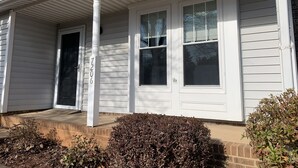 A house with a covered porch, a front door, and two windows. - Amazing home for 6 ! (Charlotte)