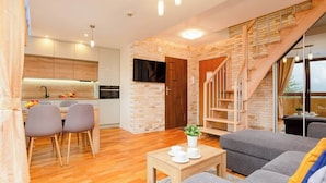 A modern apartment with a kitchen, dining area, living room, and a staircase leading to an upper floor. - Suite with Mountain View | Gym | Sauna. (Koscielisko)