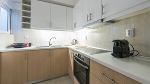 Een moderne keuken met witte kastjes, een roestvrijstalen spoelbak en een inbouwoven.