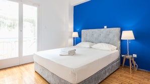 Een moderne slaapkamer met een groot bed, twee bedlampen en uitzicht door een schuifdeur.