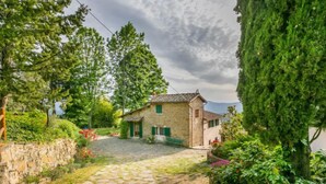 A stone house with a stone pathway leading to it, surrounded by greenery and trees. - Appartamento Piccolo by Interhome (Reggello)