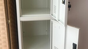 A white metal filing cabinet with multiple drawers, a keyhole, and a lock. - Million Pointz - Hostel (Amami)