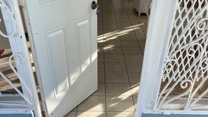 A door with a 'WELCOME' mat and a metal gate. - View 61 Hibiscus with Private pool & Beach View (St John's)