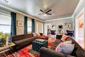 A living room with a sectional sofa, ottoman, and a ceiling fan.