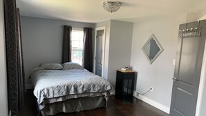Un dormitorio con cama, mesita de noche, espejo y armario.