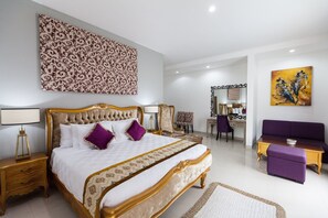 A spacious bedroom with a large bed, a desk, a chair, and a sofa.