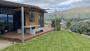 Une maison moderne avec une façade en bois, de grandes fenêtres et une terrasse.