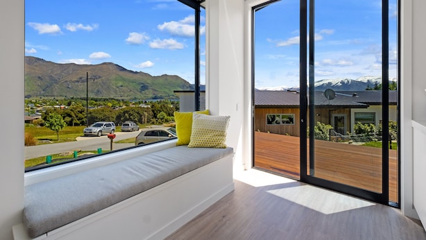 Une chambre moderne dotée d’une grande fenêtre donnant sur un paysage montagneux.