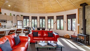Un salon moderne avec un canapé en cuir rouge, une table basse en verre et une cheminée en pierre.