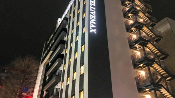 A hotel with a prominent sign reading "HOTEL LEMAX". It features multiple floors with balconies and a modern architectural design.